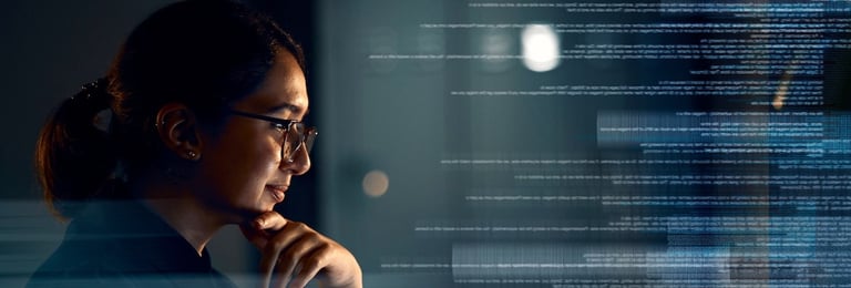 Woman working on a laptop with hologram overlay for database review at night