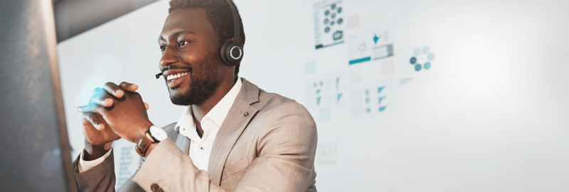 A sales professional smiling at a computer