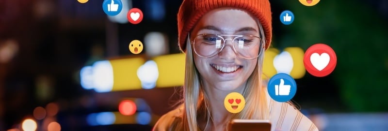 vlogger or influencer is receiving emoji and emoticon reactions in her mobile smart phone device while making a post