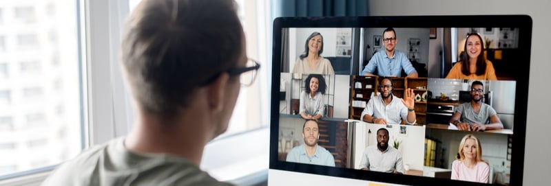 View from back above male shoulder on the laptop with diverse employees, coworkers on the screen, video call, online meeting.