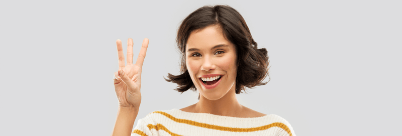 Woman smiling and holding up three fingers