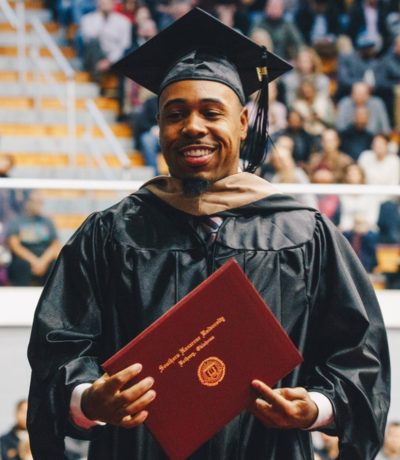 Graduate holding diploma from Southern Nazarene University