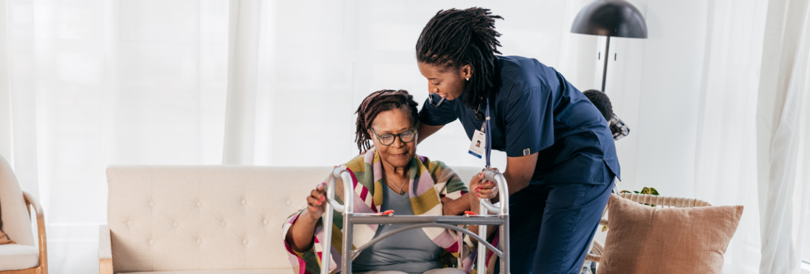 An elderly woman in a wheelchair being taken care of by a senior living care-taker