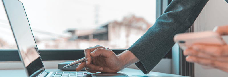 Close up image of two hands working on a laptop 