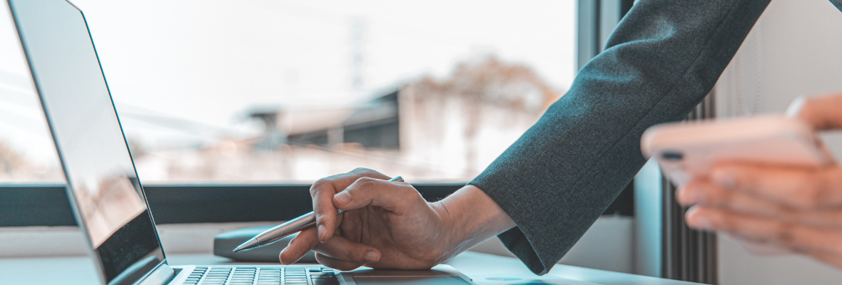 Close up image of two hands working on a laptop 