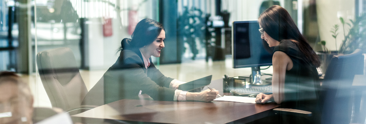 a marketing consultant showing some paperwork to her client 