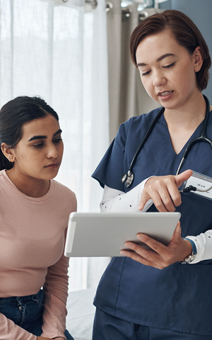 un médecin montrant une tablette à un patient