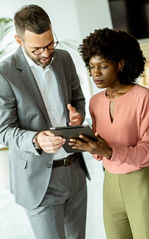 two professional collaborating over a tablet