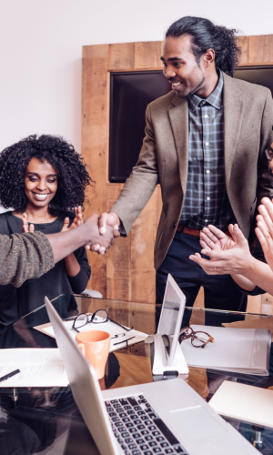 man shaking hands at a conference room while smiling